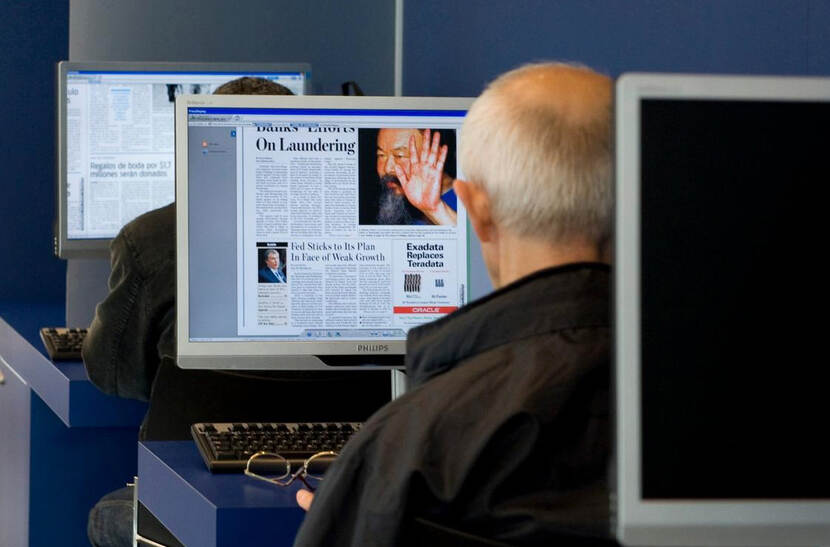 Mensen lezen de krant digitaal in een bibliotheek