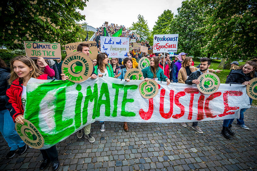 Decoratieve afbeelding van deelnemers aan een tweede klimaatmars lopen door de Maastrichtse binnenstad. De klimaatactivisten willen dat het klimaatakkoord van Parijs strikt gevolgd wordt door de stad